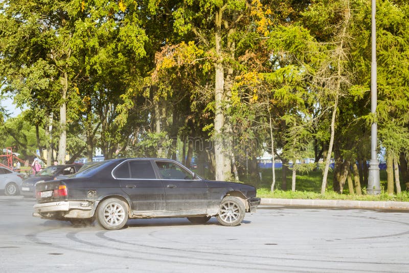 Старый автомобиль BMW 5-й серии E34 дрейфует. Санкт-Петербург. Россия-3 августа 2013 года: старый автомобиль BMW 5-series e34 дрейфует на дороге, встречая поклонников баварского роялти-стокового изображения