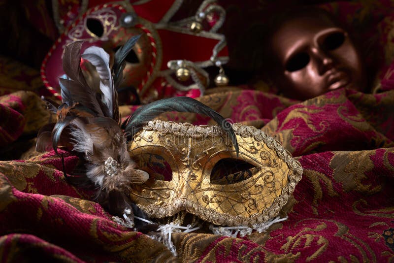 Old masquerade Venetian carnival masks on a dark curtain. Old masquerade Venetian carnival masks on a dark curtain.