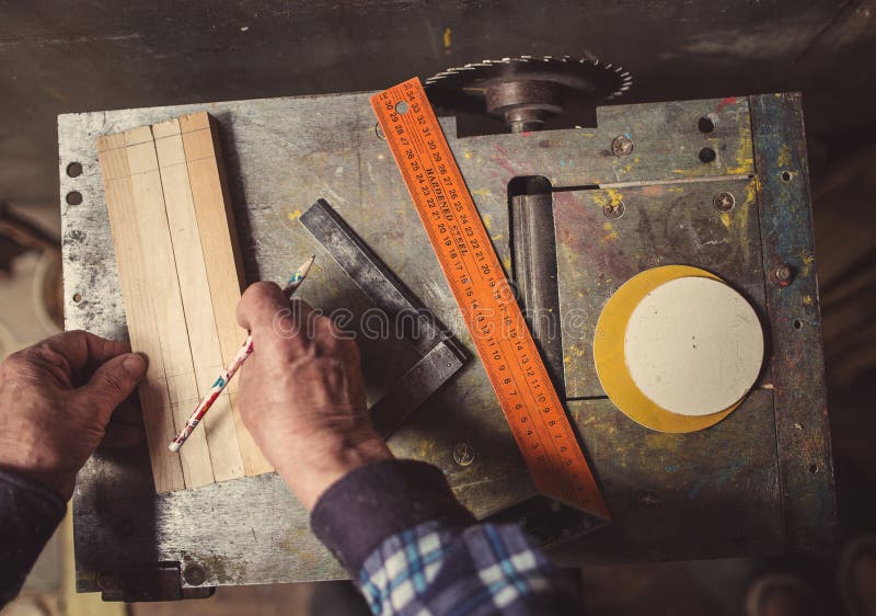 Old carpenter working with wood, retro tinted