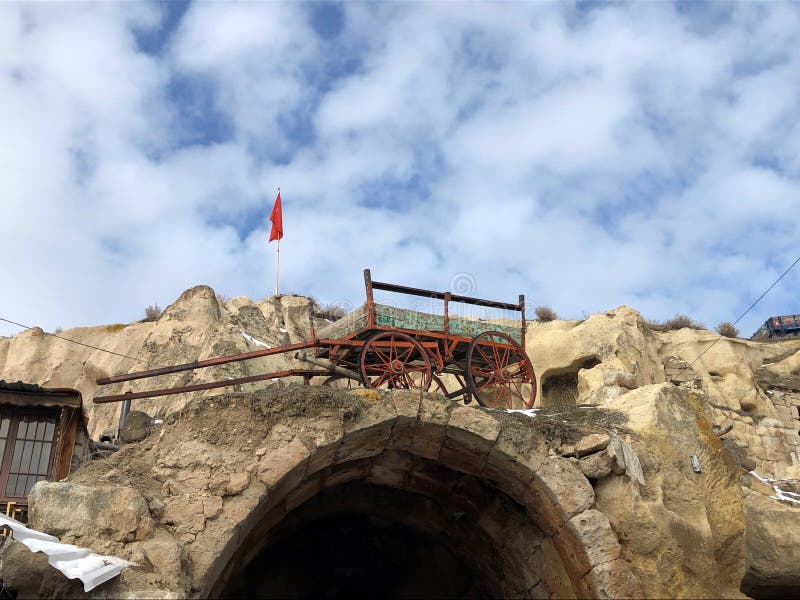 An old cart on the edge of a stone wall. A poor Turkish village in the Cappadocia region.