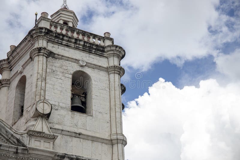 Old catholic church. White stone bell tower on blue sky background. Basilica de Santo Nino in Cebu