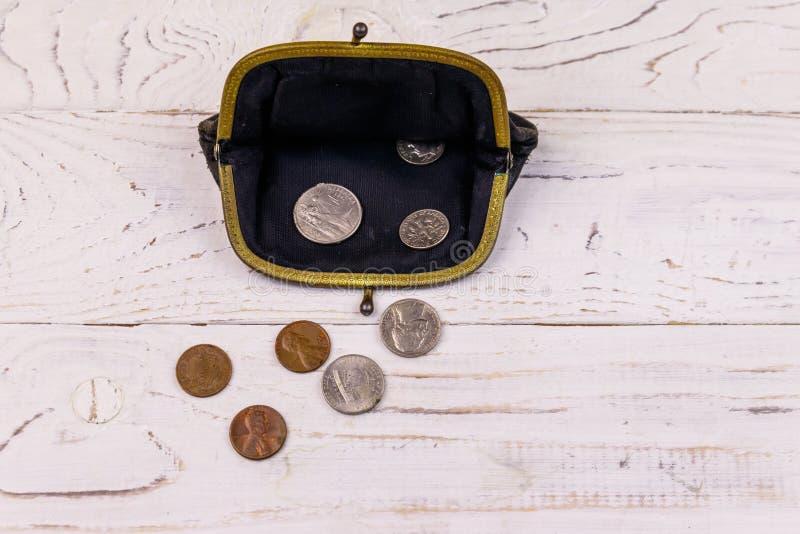 Old change purse with several coins on a white wooden background. Concept of poverty or bankruptcy