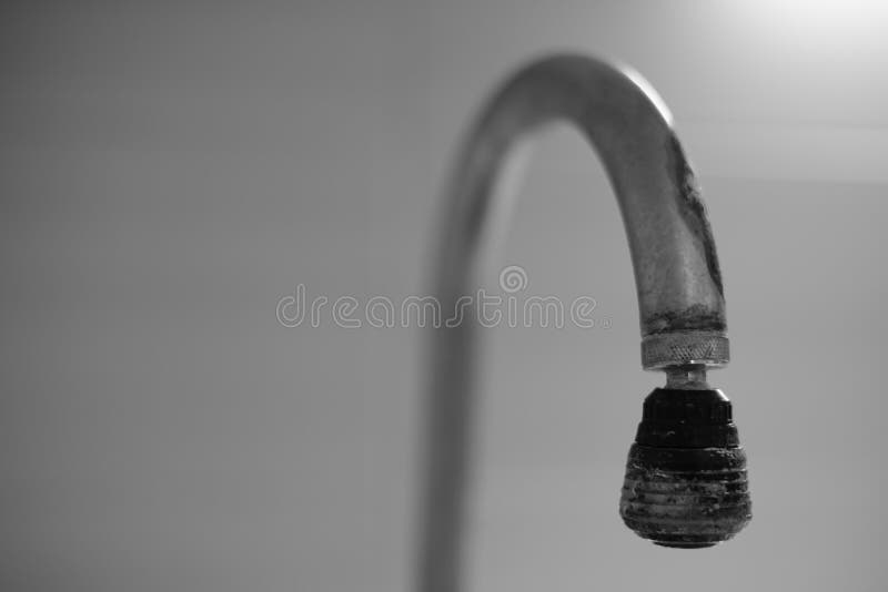 Old chrome faucet in lime. Black and white photo