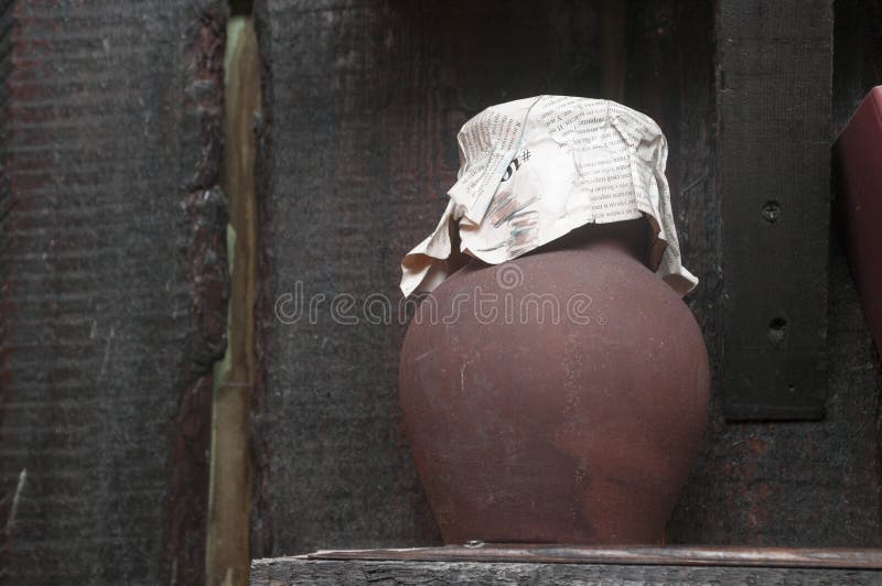 An old clay milk jug, covered with a white cloth stock photography