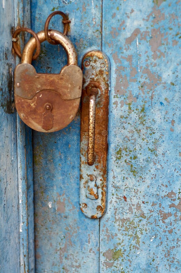 Old closed padlock rusty on wooden weathered door