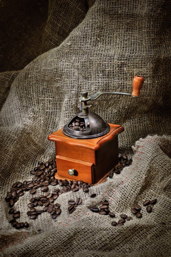 Old Coffee Grinder with Coffee Beans on Brown Burlap Stock Image