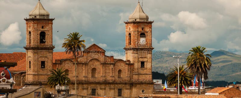 Old colonial stone church with roofs and palm tree