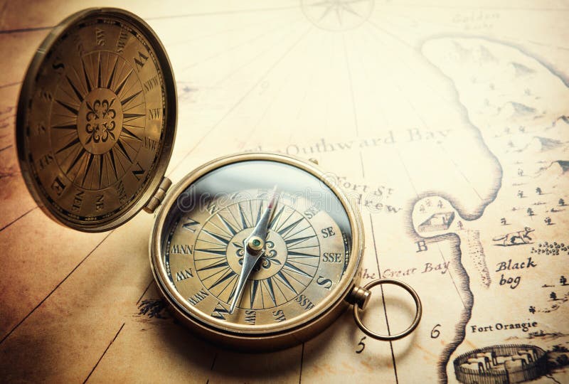 Old compass on vintage map. Adventure stories background.