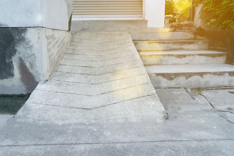 Old concrete slope path beside stairs with moss stain