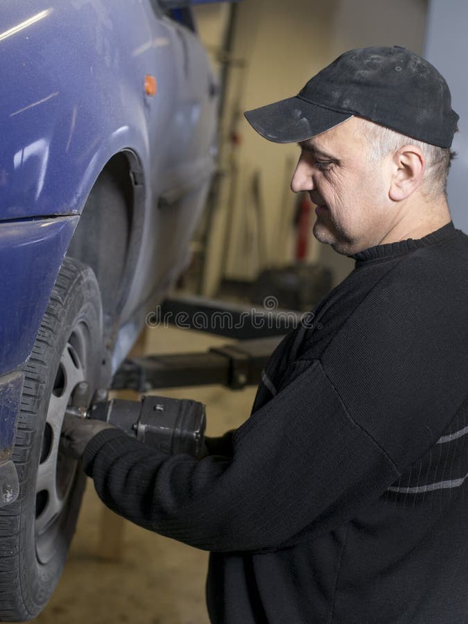 Old content mechanic fixing old car stock photo