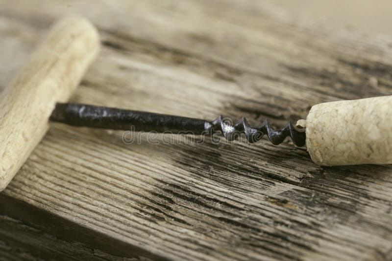 Old Corkscrew and Wine Cork on Wooden Surface Macro Closeup Stock Photo