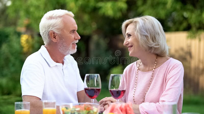 Old couple celebrating anniversary, drinking wine, everlasting love relations stock photos Old couple celebrating anniversary, drinking wine, everlasting love relations stock photos