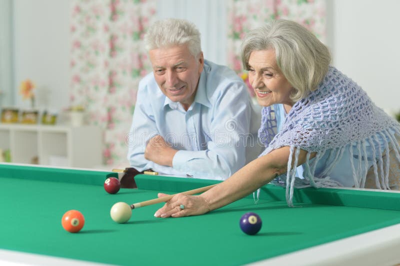 Old couple playing billiard