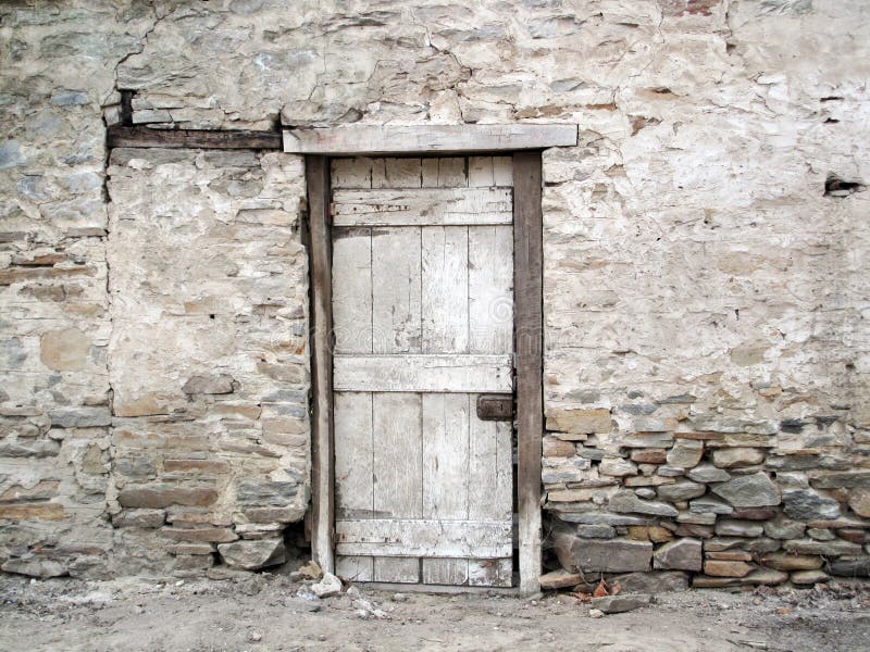 A weather beaten old ruin rock wall building and wooden door. Photo taken in a small South Australian town. A weather beaten old ruin rock wall building and wooden door. Photo taken in a small South Australian town.