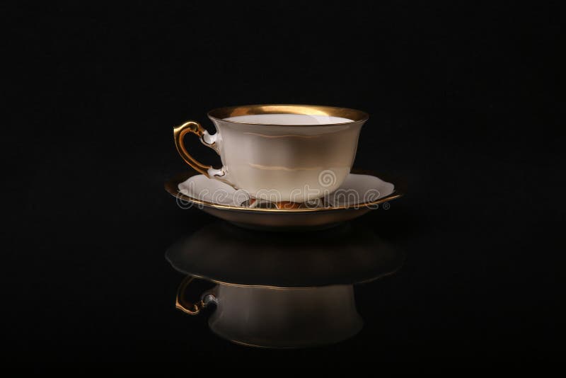 Old Cup And Saucer Reflected On Black Background Stock Photo