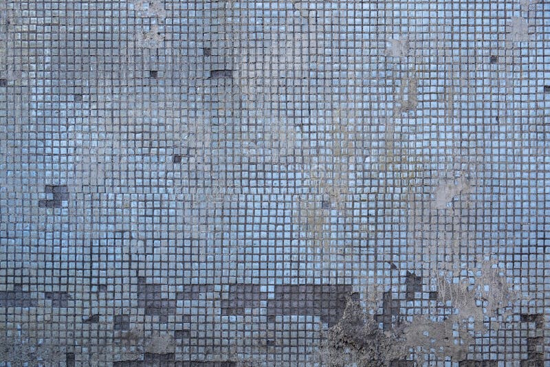 Old Damaged Concrete Wall with Fine Blue Ceramic Tiles and Stains of Gray Cement. Rough Surface