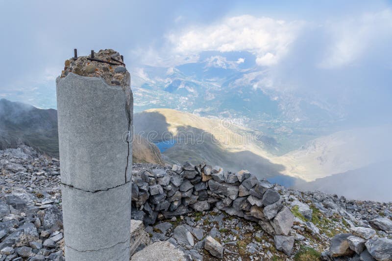 Old Damaged Stone Column with the View of Mountains Under a Blue Cloudy