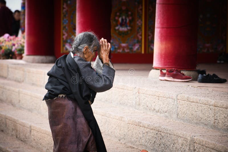 Old devoted believer praying in front of the Langmusi Temple in China stock image