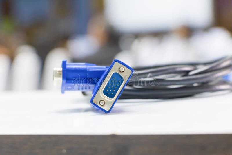 Old dirty VGA tech cable connector of computer on table white Blur meeting room background royalty free stock image