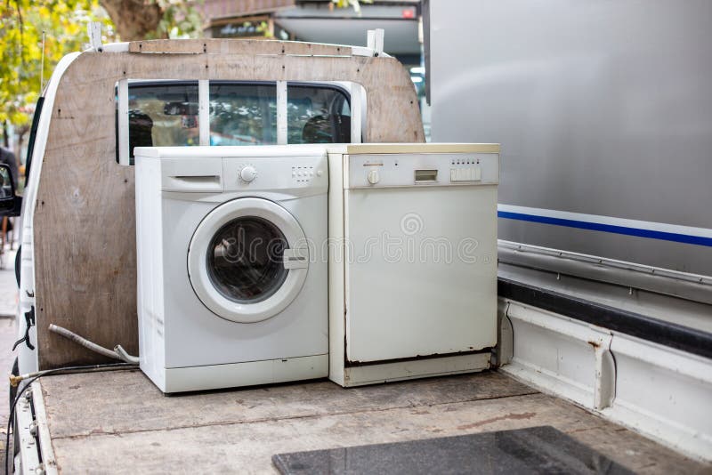 Old discarted dishwasher and washing machine on a vehicle truck