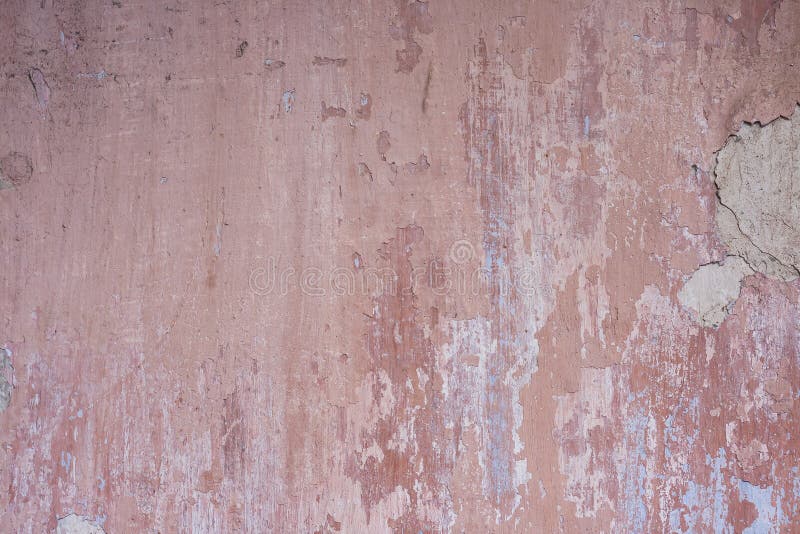 Old distressed wall with pink peeling plaster stock photography