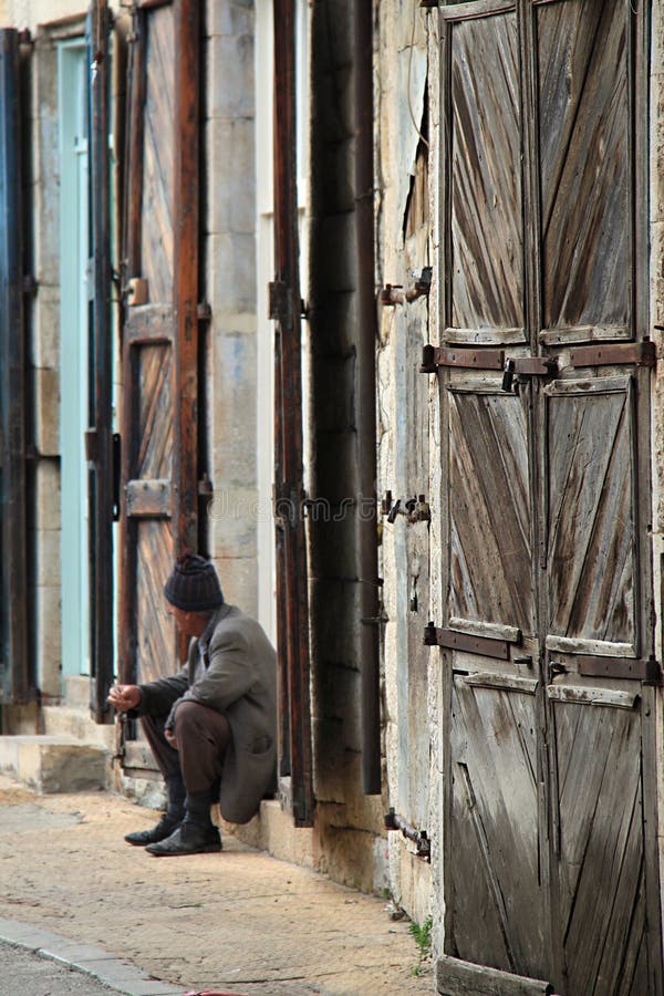 An old door in a Lebanese village with an old man in the background.