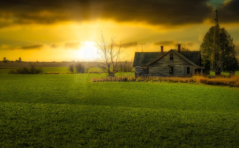 Old Farmhouse In Field At Sunset With Windmill Rural Wisconsin Cloudy