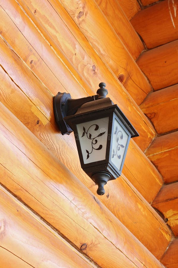 Old-fashioned lantern on logs wall stock image