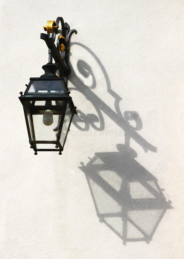 Old-fashioned lantern throwing its shadow on a wall royalty free stock photos