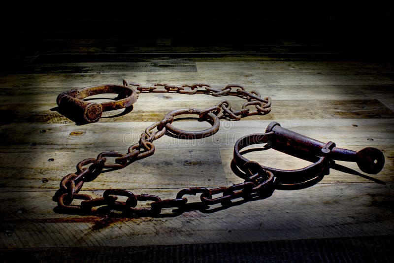 Old fashioned, vintage shackles on a rustic wooden background.