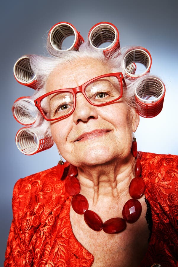 Portrait of an elderly woman in curlers looking at camera.