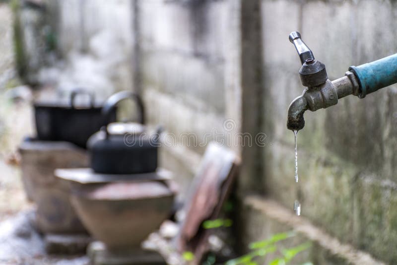 Old Faucet With Water Leaking Drop To The Ground Stock Photo