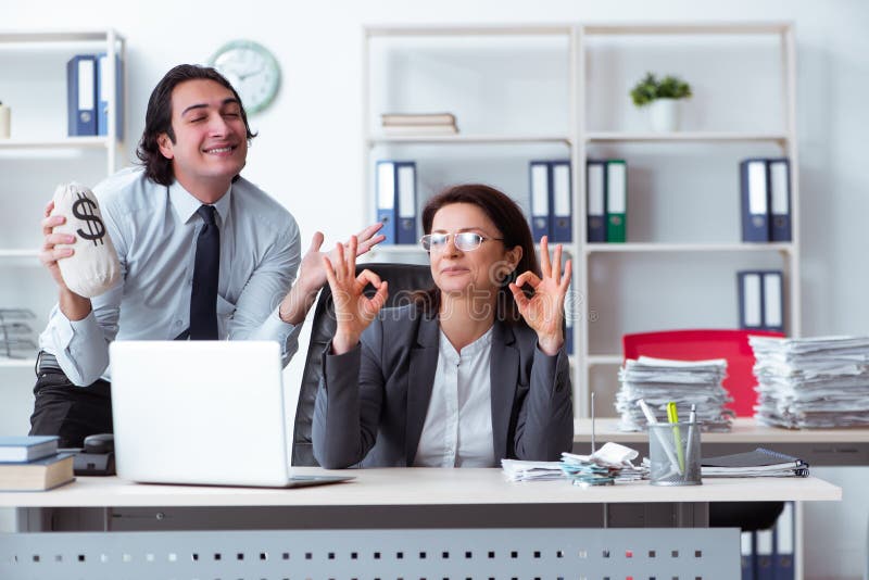 The old female boss and young male employee in the office royalty free stock image