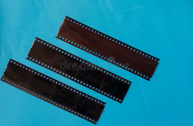 Old Film Negatives on a Plain Blue Colour Background Stock Photo