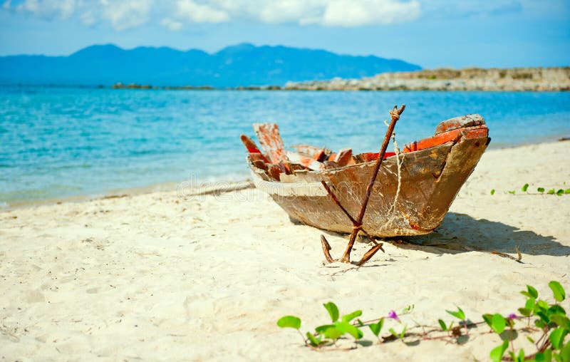 Old fisherman boat with anchor on the beach