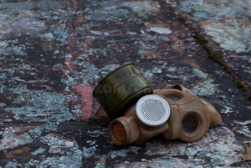 The old gas mask lies on a destroyed concrete floor, a symbol of