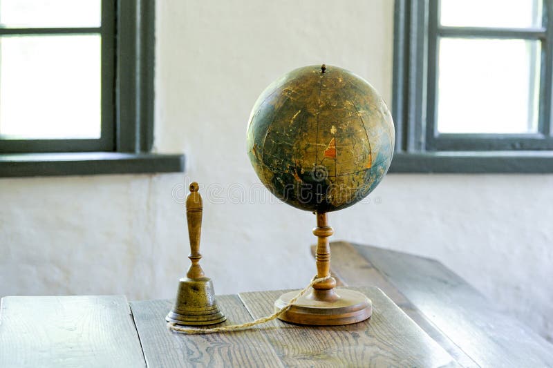 An old globe lying on a table  against the background class room. Retro style. Science, education, travel, vintage background