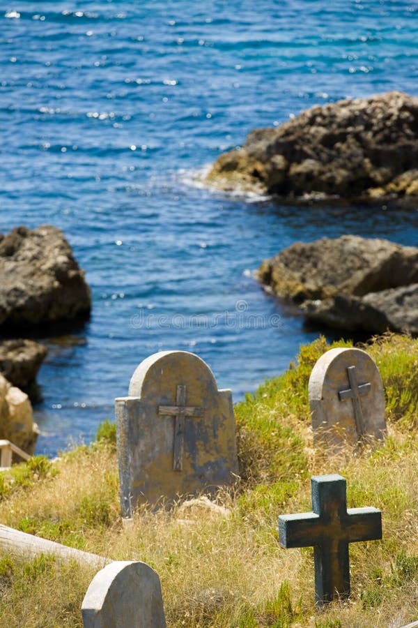 Old graveyard next to the water edge, rocks and sea of Malta