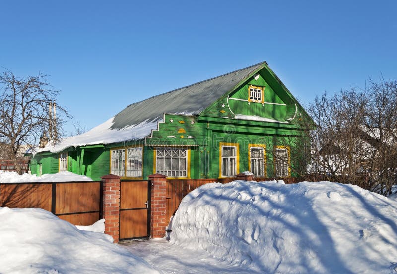 Green wooden house in winter