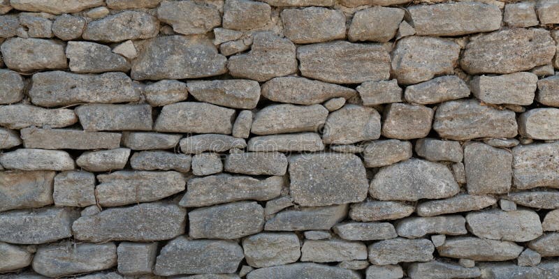 Old Grey stone wall made of large gray small rectangular hewn natural stones