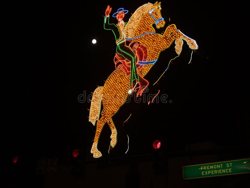 Old Hacienda neon horse and rider over Fremont Street Experience road sign