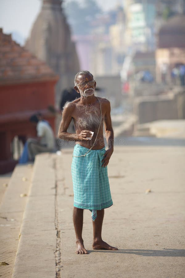 Old Hairy Indian Man Drinking Tea at River Ganges, Editorial Stock