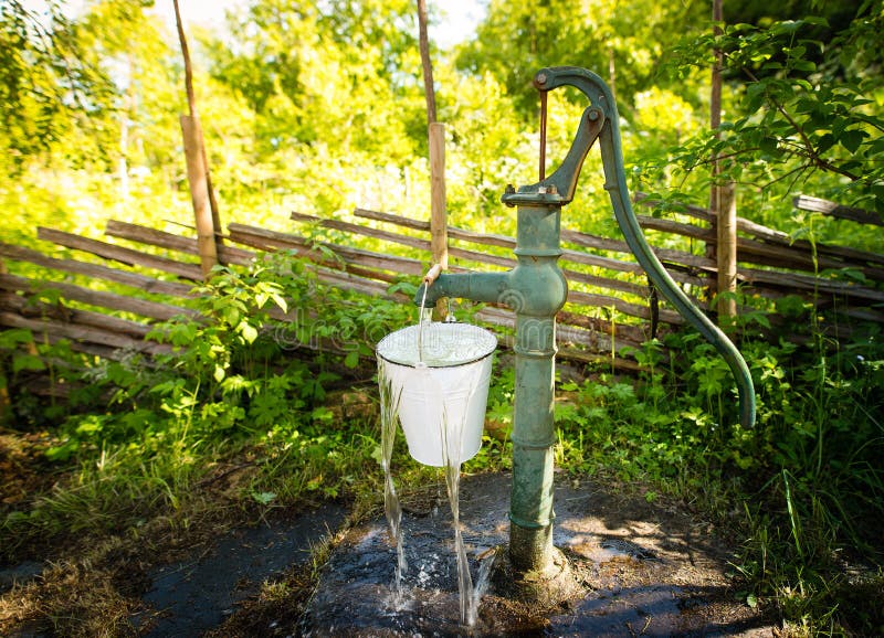 Old hand water pump outside in the garden