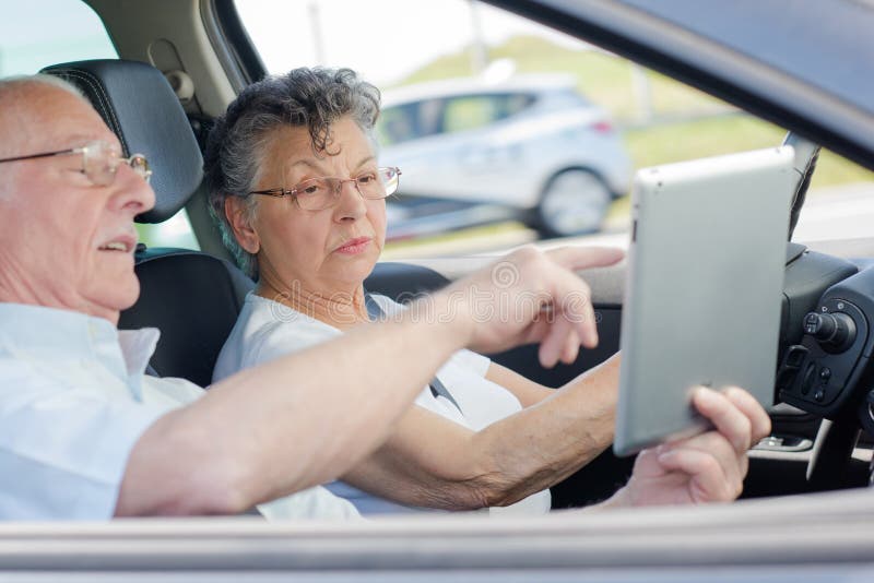 Old happy people enjoying road trip in car