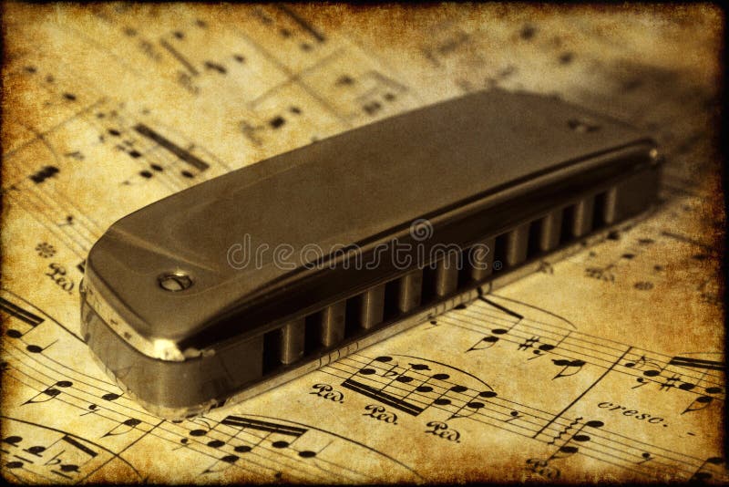 Old harmonica on the music sheet