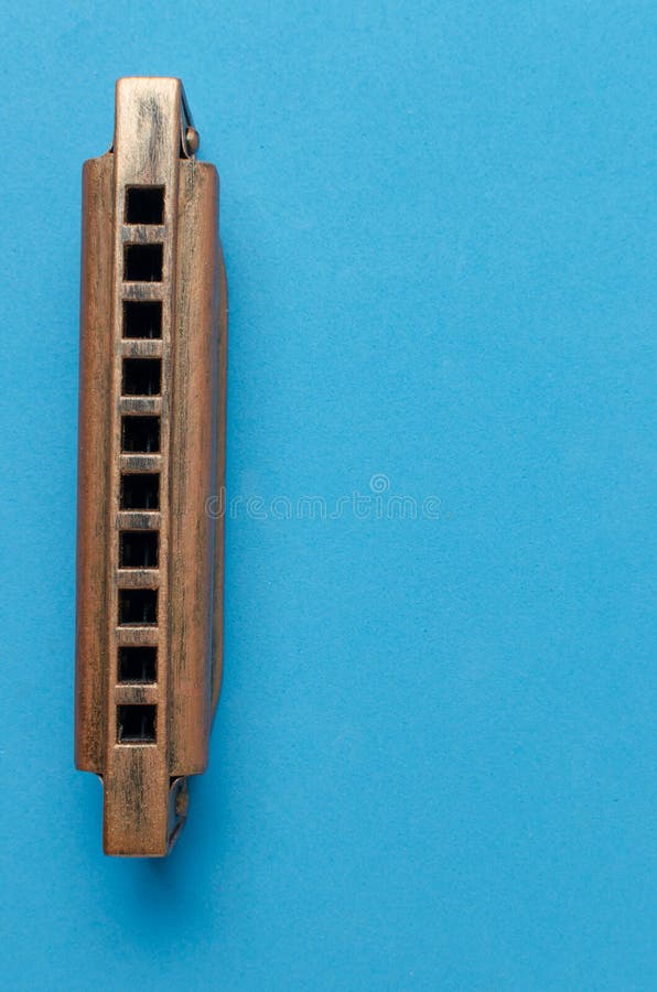 Old Harmonica on a Blue Background. Stock Photo Image of sound, music