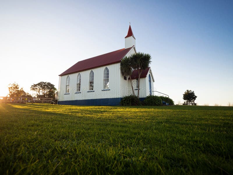 Old historic 19th century white presbyterian Awhitu Central Church with green grass during sunset on Manukau Heads Peninsula Auckland North Island New Zealand. Old historic 19th century white presbyterian Awhitu Central Church with green grass during sunset on Manukau Heads Peninsula Auckland North Island New Zealand