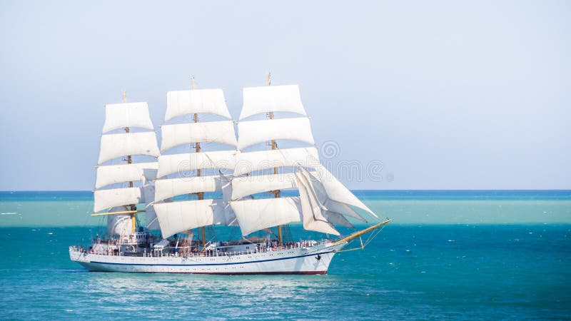 Old historical tall ship with white sails in blue sea russia