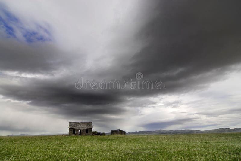 Old House in Field with Storm Clouds