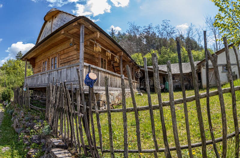 Starý dom na dedine na Slovensku, drevenica za dreveným plotom a na nej modrý keramický hrnček. takto dlho li